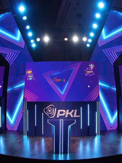 A full view of the impressive stage we designed and built for the PKL Player Auction. The geometric neon lighting and multiple LED screens create a modern and professional environment fit for a premier sports league.