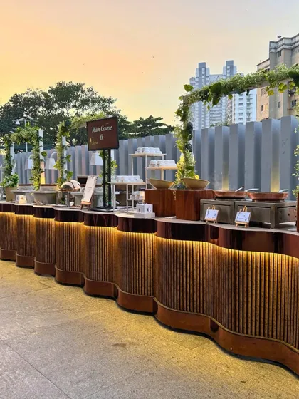 Our expertise extends to creating stunning outdoor buffet experiences. This beautifully lit, serpentine counter set against the city skyline showcases a modern and sophisticated setup, perfect for an evening corporate event.