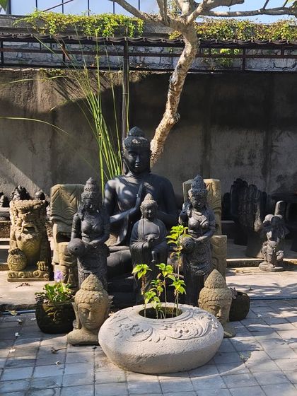 A full setup of Balinese-style stone statues and planters, ready to create a spiritual and tranquil corner in a garden.