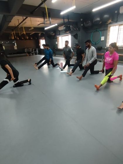 A group of students works on hamstring and hip flexibility. We teach a holistic approach to fitness, where mobility is as important as strength.