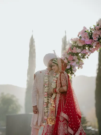 A romantic kiss under the floral arch at sunset. A truly magical and timeless wedding portrait.