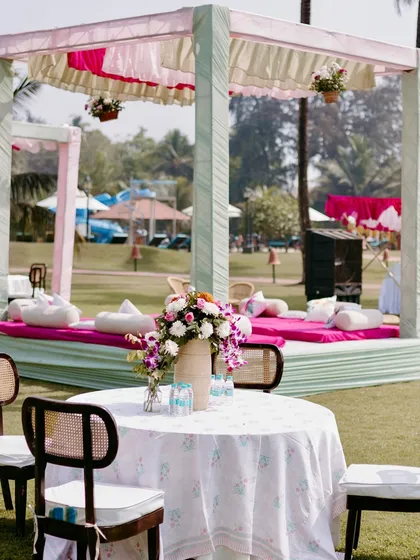 Low seating arrangements with comfortable mattresses and cushions under a pastel canopy, perfect for guests to relax and get their henna done at this breezy Goa Mehendi.