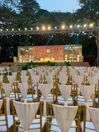 A view from the guest's perspective, looking towards the grand floral stage under a professionally lit truss, ready for an evening of celebration.