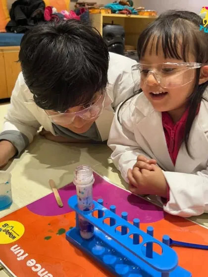 A moment of discovery between two budding scientists. Collaborative experiments like this teach teamwork and problem-solving as they watch their creation come to life in a test tube.