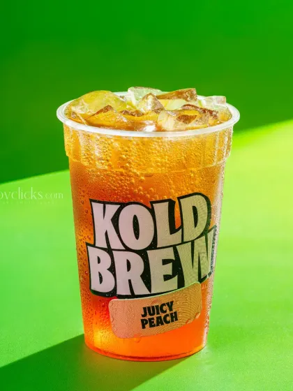 A juicy peach-flavored iced tea, with condensation on the cup to emphasize its coldness.