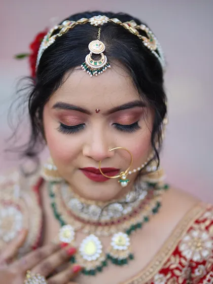 A detailed close-up of the eye makeup for a red lehenga look. The blend of copper and bronze tones adds warmth and definition to the eyes.