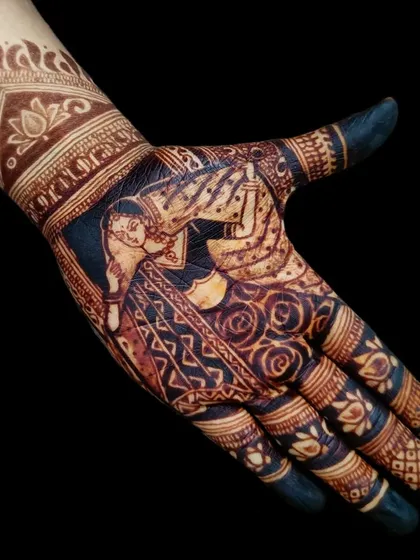 The rich, dark stain of a bridal portrait design. This shows the beautiful final color of a detailed bride figure after the henna paste is removed.