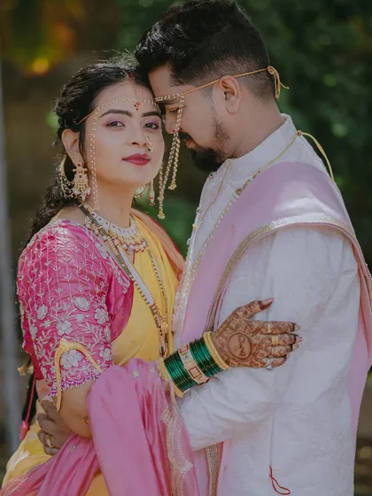 A close-up portrait where the bride looks at the camera with confidence, her traditional mundavalya beautifully featured.
