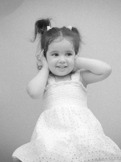 A beautiful black and white portrait of a two-year-old girl, emphasizing her sweet expression and the soft lighting.