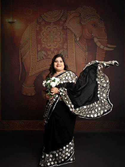 A graceful portrait featuring a flowing saree against a traditional, artistic backdrop. This shot combines elegance with cultural beauty to celebrate a special milestone.