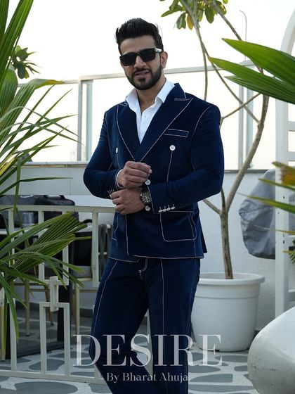 A full-length view of the blue velvet suit. The double-breasted design and tailored fit create a look of modern, luxurious power.