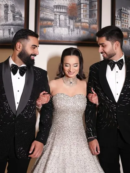 A beautiful moment between a bride and her two smartly dressed brothers, both wearing my custom-designed black sequined tuxedos. It's an honor to dress the entire family for such special occasions.