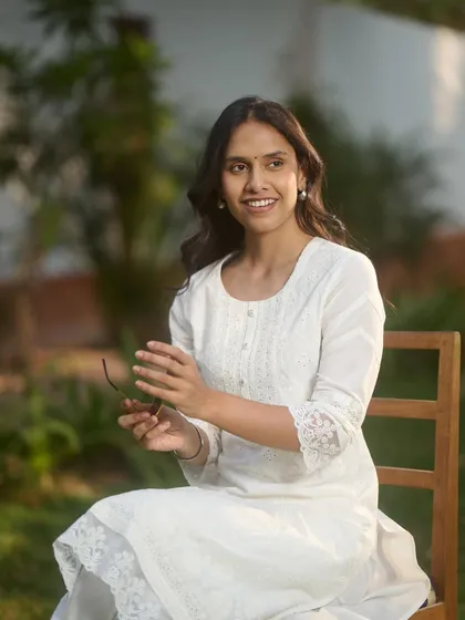 A bright and fresh look for a summer collection. The makeup is minimal with a focus on healthy, glowing skin and a simple hairstyle, allowing the classic white kurta to stand out.