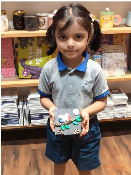 This little girl carefully holds her delicate clay art piece. I guide children step-by-step so they can create things they are proud of.