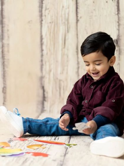 A candid moment of a toddler playing during his second birthday session. We incorporate playtime to keep children engaged and happy.