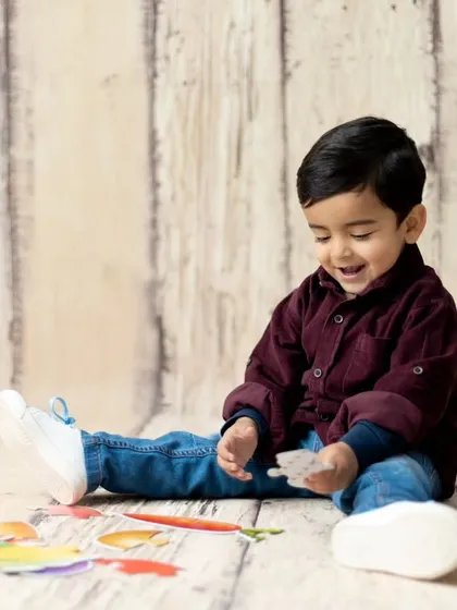 A candid moment of a toddler playing during his second birthday session. We incorporate playtime to keep children engaged and happy.