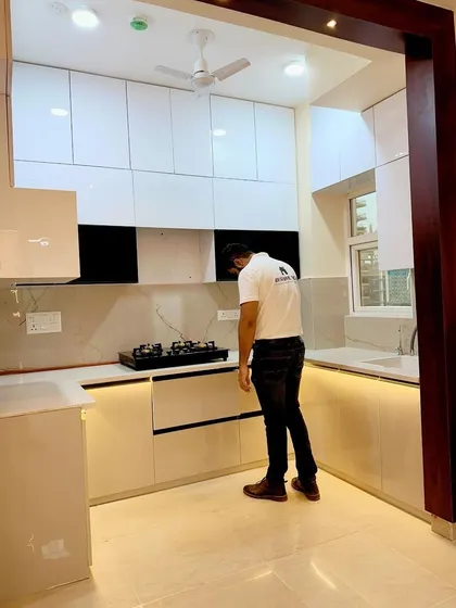 Final inspection of the drawers and cabinets in this U-shaped kitchen. The design is clean, bright, and highly functional.