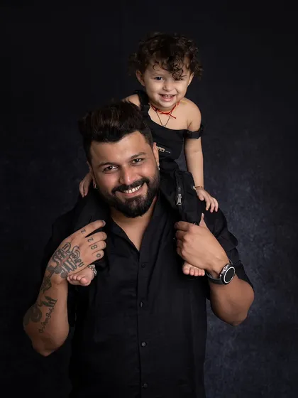 A classic father and son portrait, with the little one enjoying a ride on his dad's shoulders.