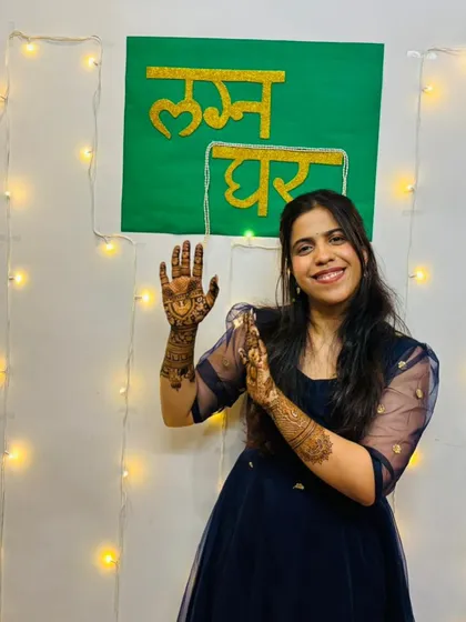 A fun shot of the bride against a festive "Lagna Ghar" (wedding house) backdrop.