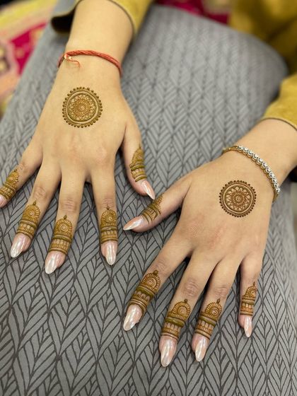 This design shows how you can have beautiful mehandi without covering your whole hand. The focus is on the fingers and a central motif.