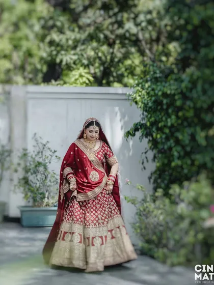 A candid shot of the bride walking in the garden, capturing the natural movement and flow of her beautiful lehenga.