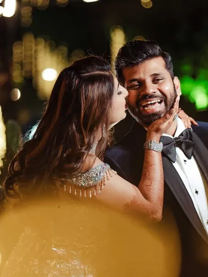 A magical moment framed by fairy lights. Neelam's spontaneous kiss and Moiz's joyful reaction are perfectly captured, showing how unscripted love creates the best photos.