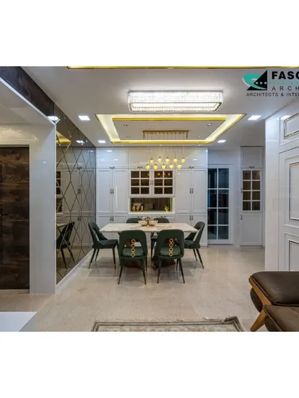 An elegant dining area in an L&T Seawoods residence, viewed from the living room. The space is defined by a crystal chandelier and a wall of white paneled storage, creating a bright and sophisticated atmosphere.