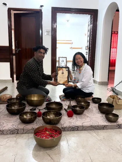 A student is awarded her certificate, a recognition of her commitment to learning the art of sound healing.