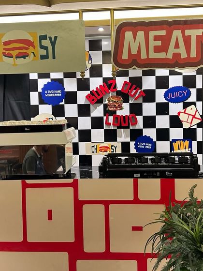 Another angle of the pop-up counter setup, featuring fun, quirky branding elements like "CHEESY" and "MEATY". We ensure every detail of the event space reflects the client's brand personality.