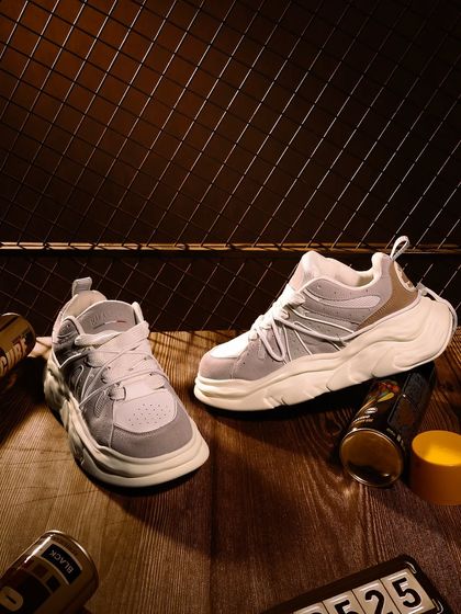 A lifestyle-inspired still life, placing these chunky sneakers in a rustic, industrial setting to give them an urban, edgy vibe.