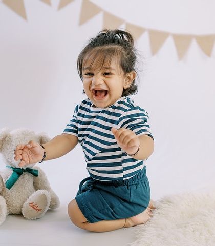 Pure, uncontainable laughter. This little boy playing with his teddy bear shows the genuine joy we aim to capture in every session.