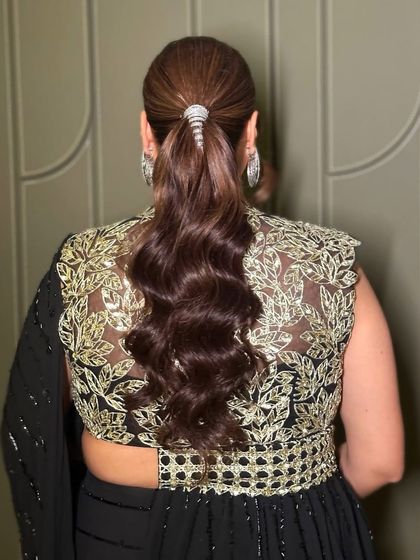 A detailed shot of the chic ponytail that completes this cocktail look, showing how hair and makeup work together to create a polished finish.