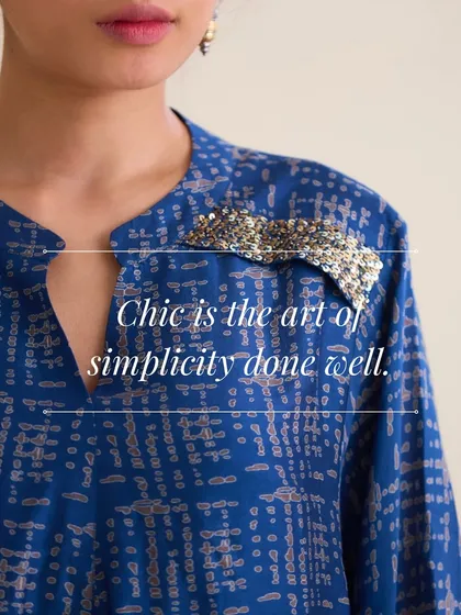Chic is the art of simplicity done well. This image highlights the delicate, sparkling hand-embroidered patch on the shoulder of our blue printed tunic. It’s a small detail that makes a big impact.