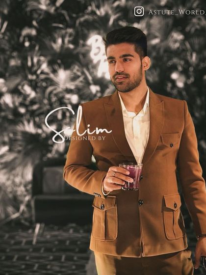 A client enjoying a drink in a brown safari-style jacket. This versatile piece can be dressed up or down for various social settings.