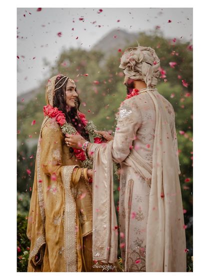 A classic Varmala exchange shot, with petals raining down on the couple.