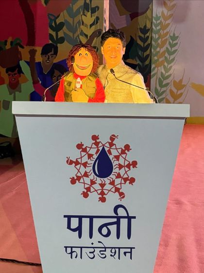 At the Paani Foundation event, standing at the podium with my puppet. We had the opportunity to address the 7000 farmers in attendance.