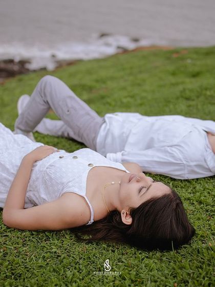 A peaceful moment lying on the grassy cliffside overlooking the ocean. This perspective offers a unique take on a coastal photoshoot.