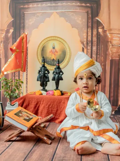 A seated portrait with the tanpura and holy book, combining different elements of the Varkari theme in one shot.