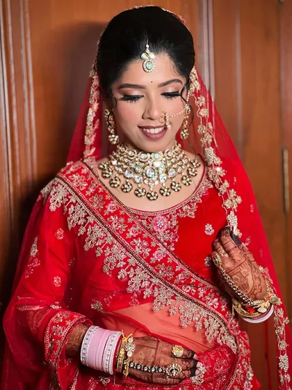 A smiling bride, looking confident in her traditional wedding attire.