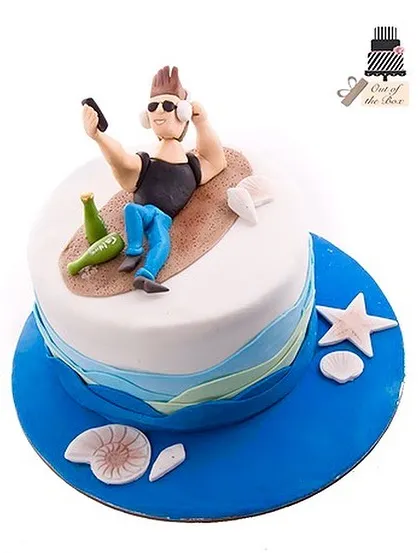 A fun beach-themed cake for someone who loves to relax, featuring a fondant figure taking a selfie on the sand.
