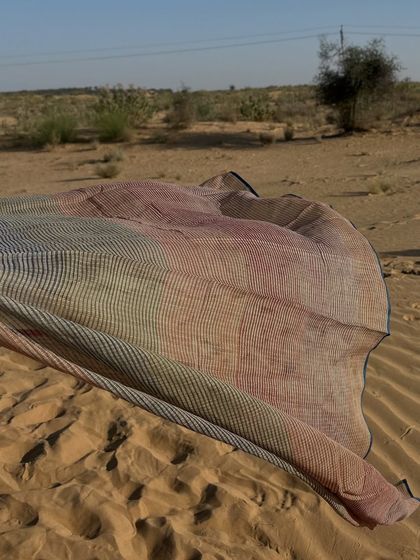 Our Paheli Kota dupatta, resting on the sands of the desert. This image captures the connection between our products and the landscapes that inspire them.
