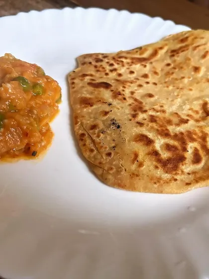 A simple and comforting meal of Baingan Bharta (roasted eggplant mash) with a soft paratha.