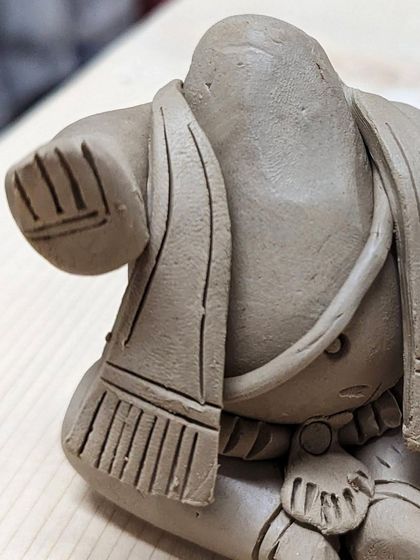 A detailed shot of the back of a Ganesha idol, showing the delicate folds of the shawl and the texture I add to each piece.