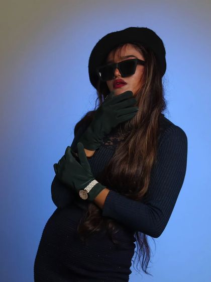 This studio shot uses accessories and a specific pose to create a high-fashion, magazine-style image.