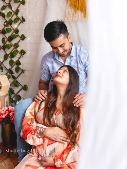 An intimate couple's portrait from a boho-style session. The soft, natural light and the loving gaze they share create a tender and heartfelt memory of their pregnancy journey.