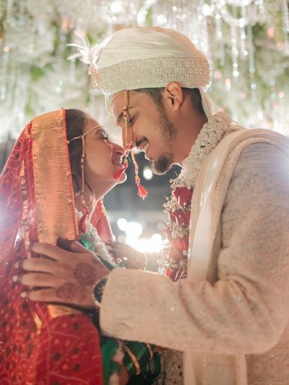 An intimate, joyful moment between the bride and groom at the end of their ceremony. The bright lights and their smiles create a magical atmosphere.