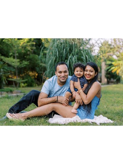A family sitting on the grass, enjoying a moment together. A simple, classic family portrait that is full of warmth.