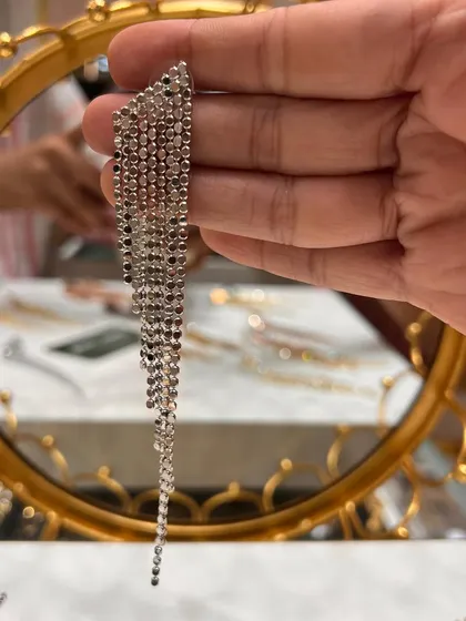 A close-up of our rhinestone-style tassel earrings in a silver finish. These are incredibly versatile and can be worn with both western and traditional outfits to add a touch of modern glam.