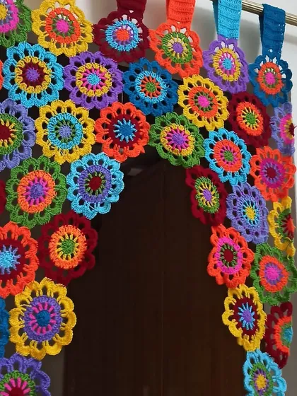 This vibrant, multi-colored floral curtain is one of my favorite statement pieces to make. Each flower is crocheted individually and then joined to create a beautiful arched valance that brings so much joy and color to a doorway or window.