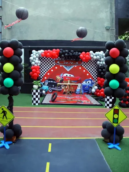 Get ready to race with this incredible Lightning McQueen 'Cars' themed party setup, featuring a race track floor and checkered flag backdrop.